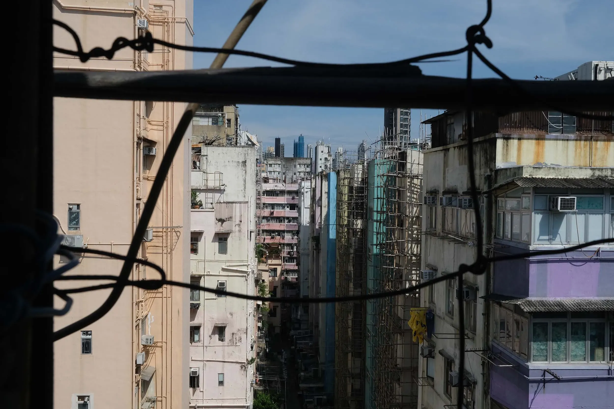 منظر من نافذة شقة ضيقة في هونغ كونغ، يظهر المباني المتقاربة في حي شام شوي بو، حيث تعاني الأسر من ظروف معيشية صعبة بسبب ارتفاع درجات الحرارة.
