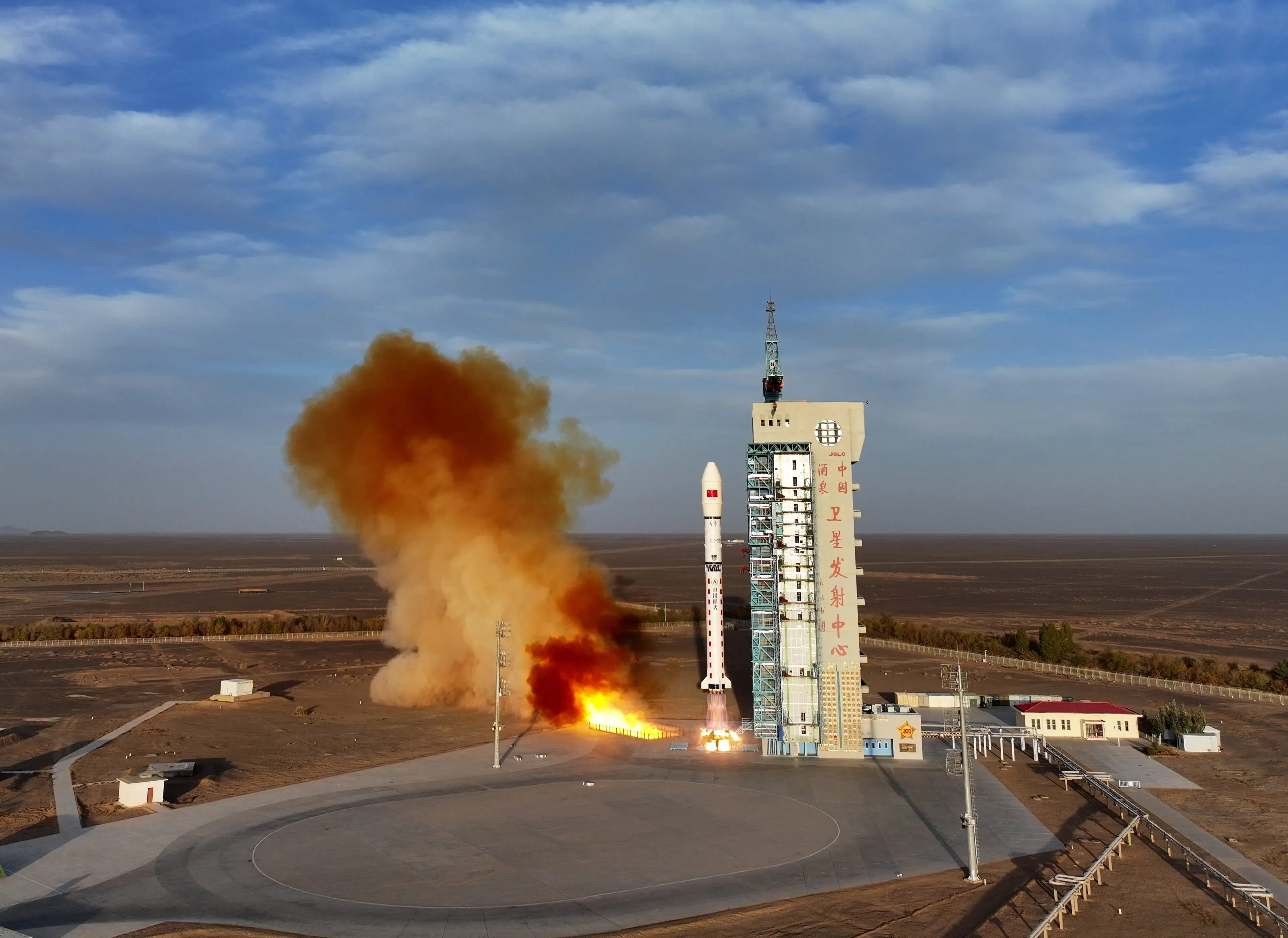 إطلاق صاروخ من منصة الإطلاق في الصين، مع سحب الدخان البرتقالي تتصاعد في السماء، مما يعكس التقدم التكنولوجي للبلاد.