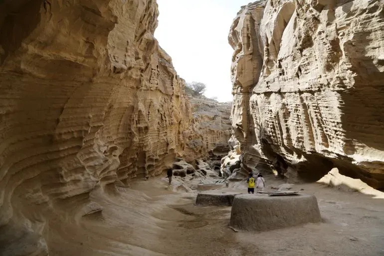 منظر لكهوف قشم الملحية، حيث يتجول زوار بين تشكيلات الصخور الفريدة، مما يعكس جمال الجزيرة وأهميتها الاستراتيجية.