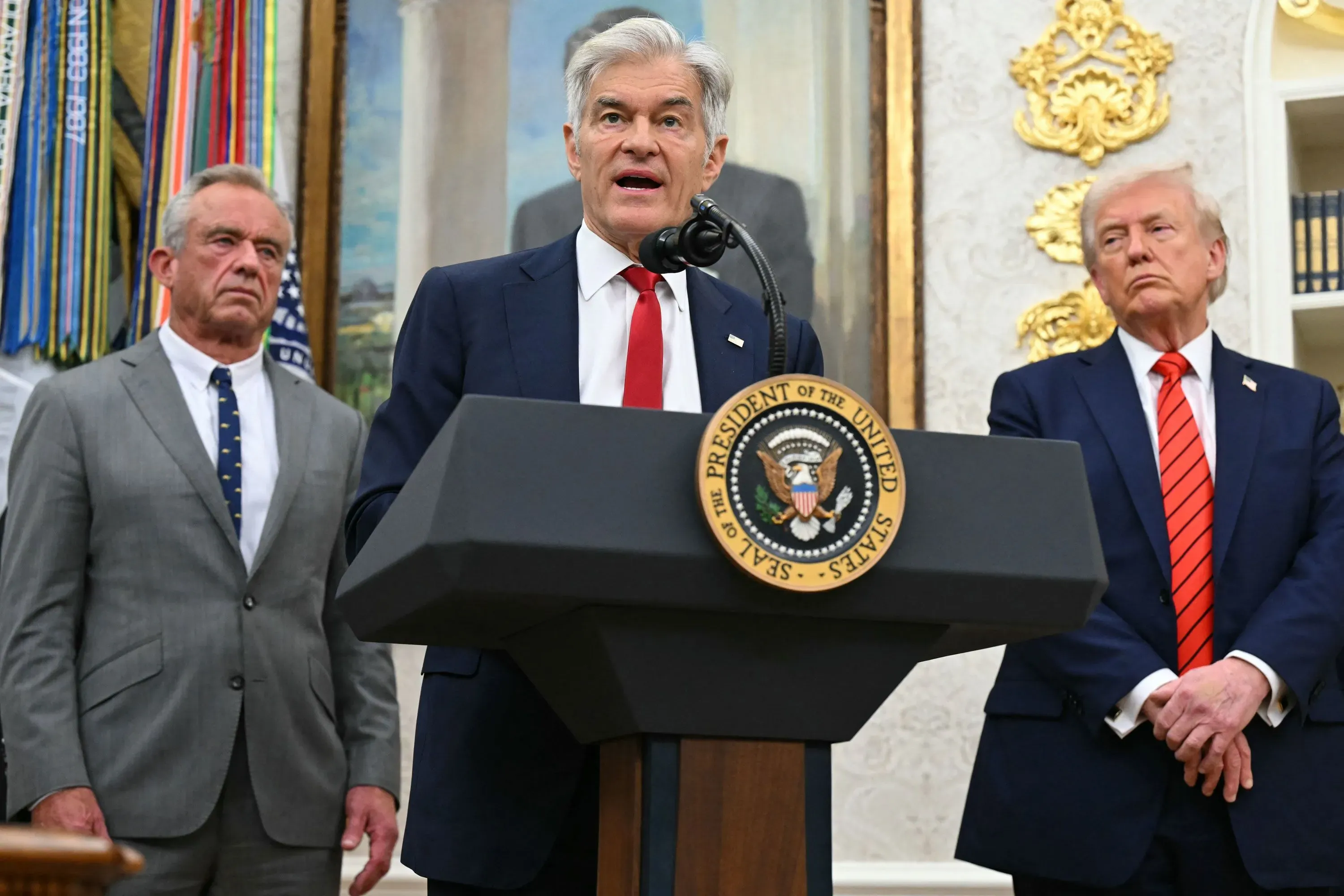 تحدث مسؤول في البيت الأبيض عن إصلاحات في نظام التأمين الصحي، مع وجود شخصين آخرين خلفه، في سياق مناقشة موضوع الإذن المسبق.