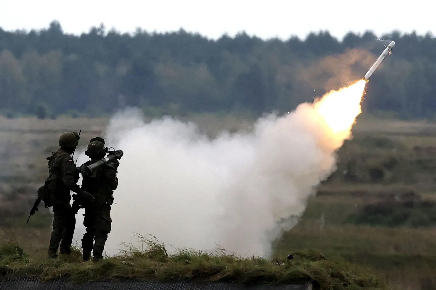 جنود يقومون بإطلاق صاروخ من نظام دفاع جوي، مع تصاعد الدخان من موقع الإطلاق، في سياق التوترات العسكرية بين الناتو وروسيا.