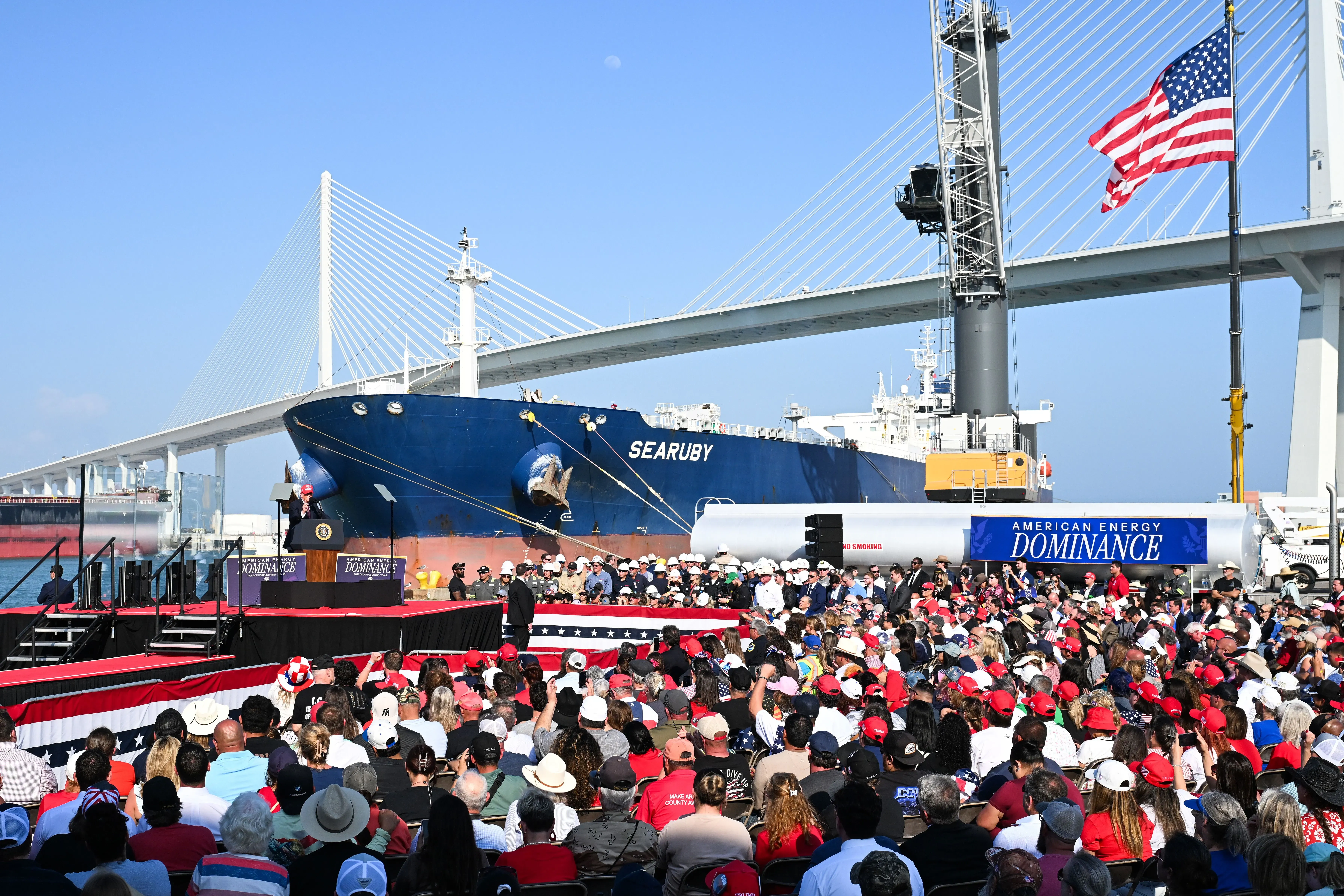 ترامب يتحدث أمام حشد كبير خلال زيارته لشركة أدوية في أوهايو، مع وجود سفينة شحن خلفه، في سياق حديثه عن الأوضاع في الشرق الأوسط.