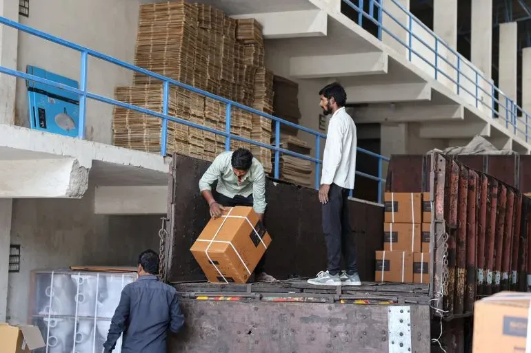 عمال يقومون بتحميل صناديق في مصنع سيراميك بموربي، الهند، حيث تأثرت الصناعة بأزمة وقود عالمية نتيجة الحرب في الشرق الأوسط.