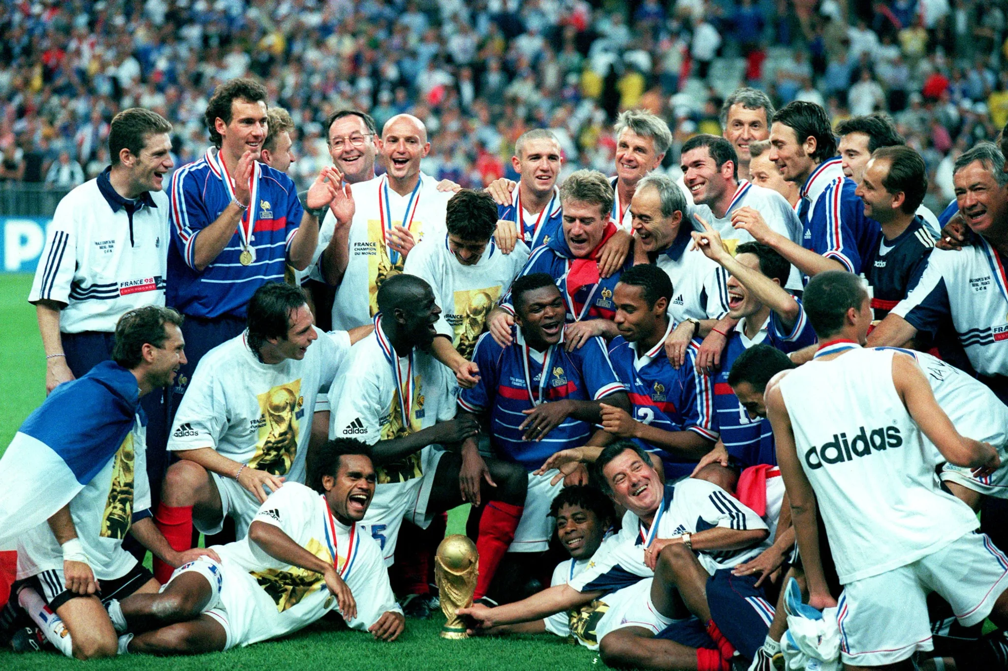 لاعبو المنتخب الفرنسي يحتفلون بكأس العالم 1998 في أجواء فرح وتآلف، رمز تاريخي لكرة القدم الفرنسية والتعددية الثقافية.