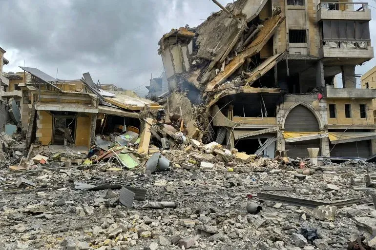 دمار هائل في منطقة سكنية بلبنان بعد غارة جوية إسرائيلية، مع أنقاض مبانٍ مدمرة وقطع من الحديد والخرسانة في الشوارع.