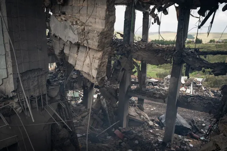 دمار كبير في مبنى نتيجة الغارات الجوية الإسرائيلية في لبنان، مع ظهور حطام وأجزاء من الجدران المتهدمة، مما يعكس آثار النزاع المستمر.