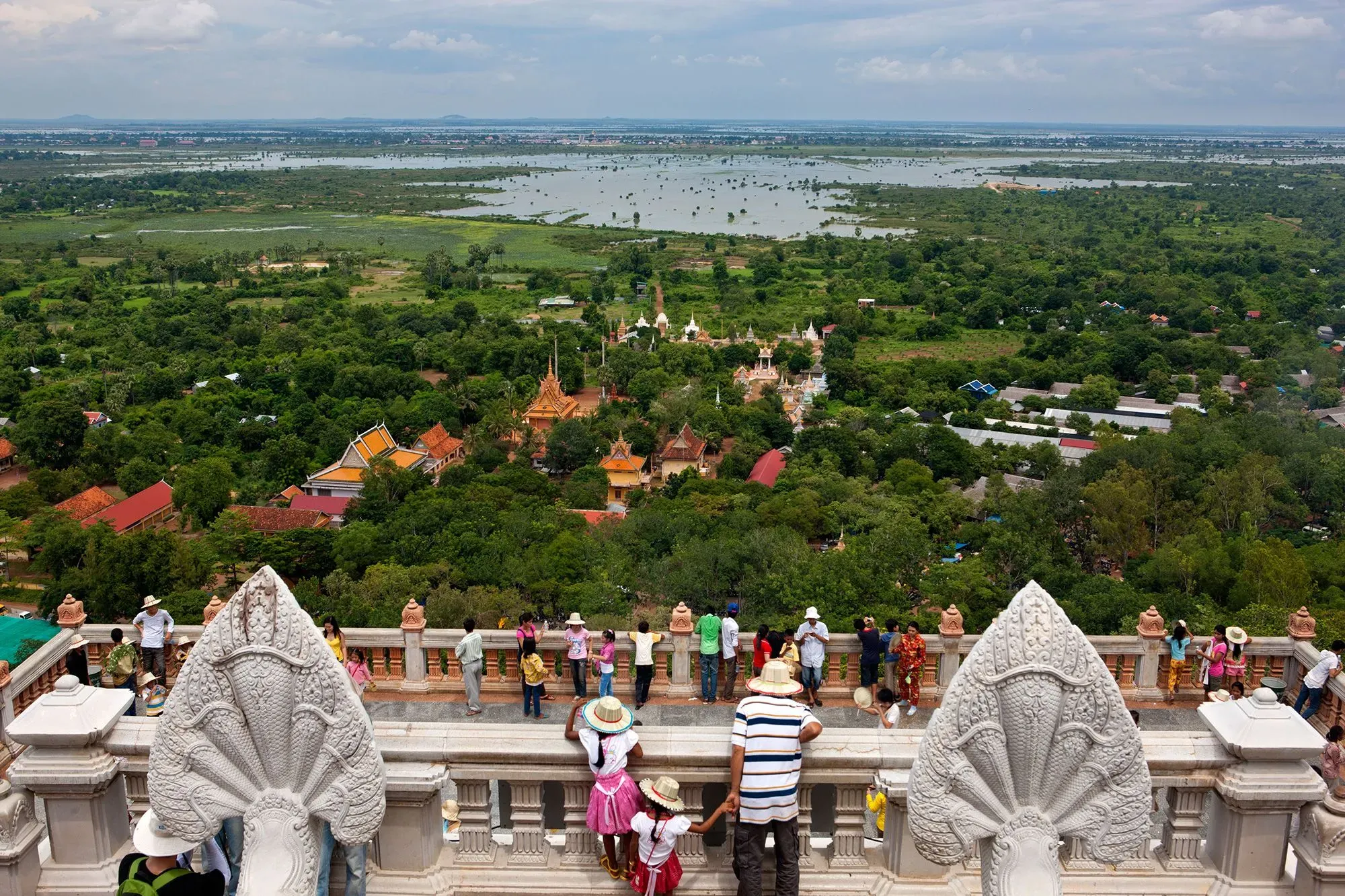 منظر بانورامي من قمة تل أودونغ، يظهر المعابد البوذية والأشجار الكثيفة، مع زوار يستمتعون بالمنظر الخلاب.