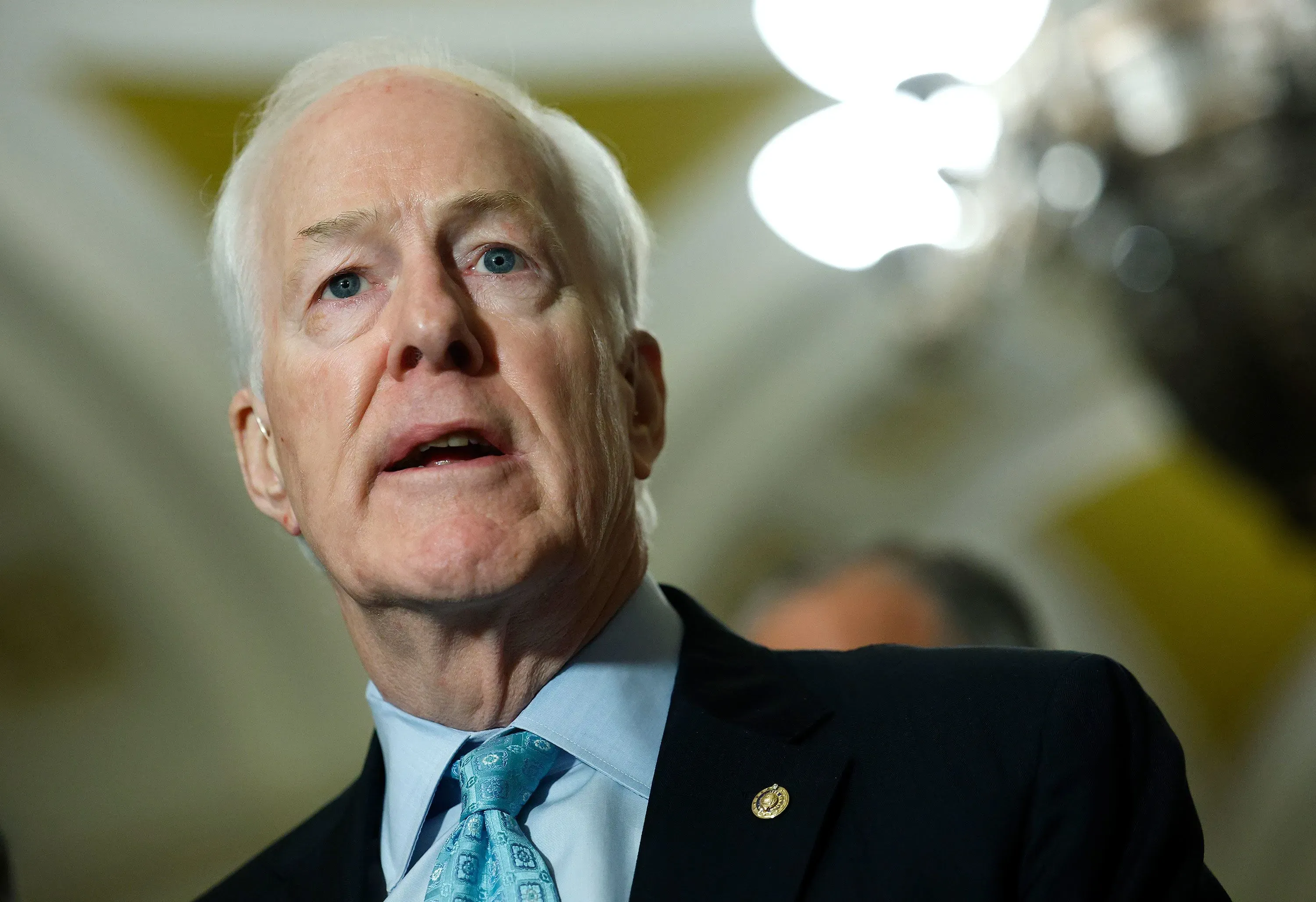 السيناتور جون كورنين يتحدث في مؤتمر صحفي، مع التركيز على قضايا الهجرة والإسلام المتطرف في سياق الانتخابات التمهيدية في تكساس.