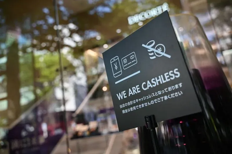 لا نقبل الدفع نقدًا، مع وجود لافتة توضح ذلك في متجر ياباني. تعكس الصورة التحول نحو الدفع الرقمي في اليابان.