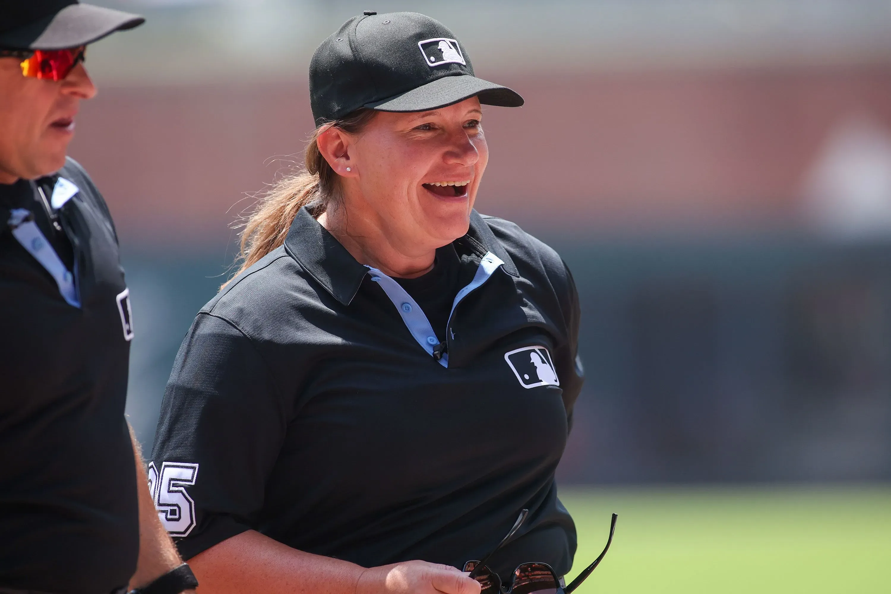جين باول، أول امرأة تحكم في مباراة دوري البيسبول الرئيسي، مبتسمة أثناء تبادل بطاقات التشكيلة في ملعب أتلانتا.
