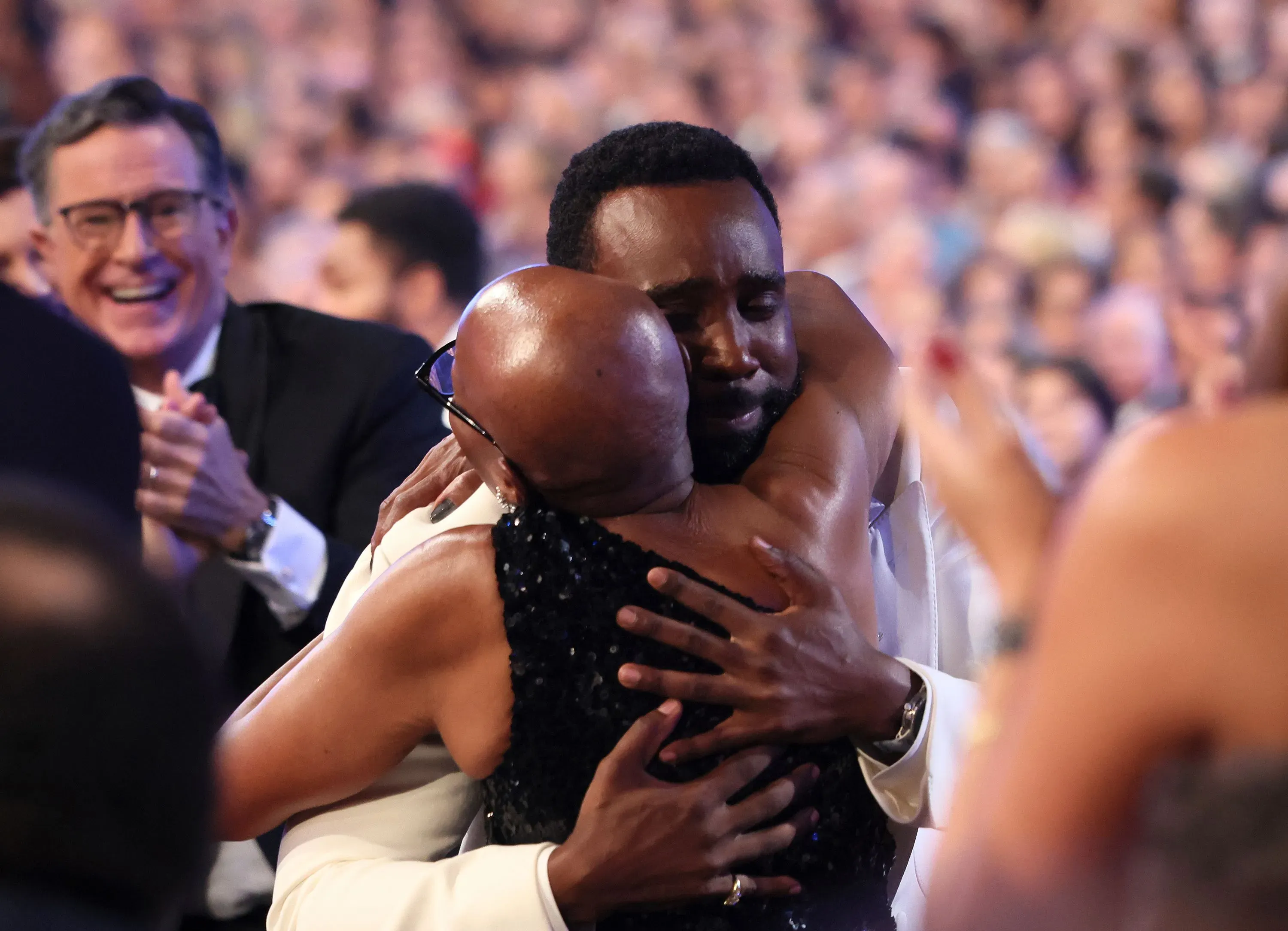 لحظة مؤثرة من حفل توزيع جوائز إيمي، حيث يحتضن تراميل تيلمان والدته بعد فوزه بجائزة إيمي، مع تفاعل حماسي من الحضور.