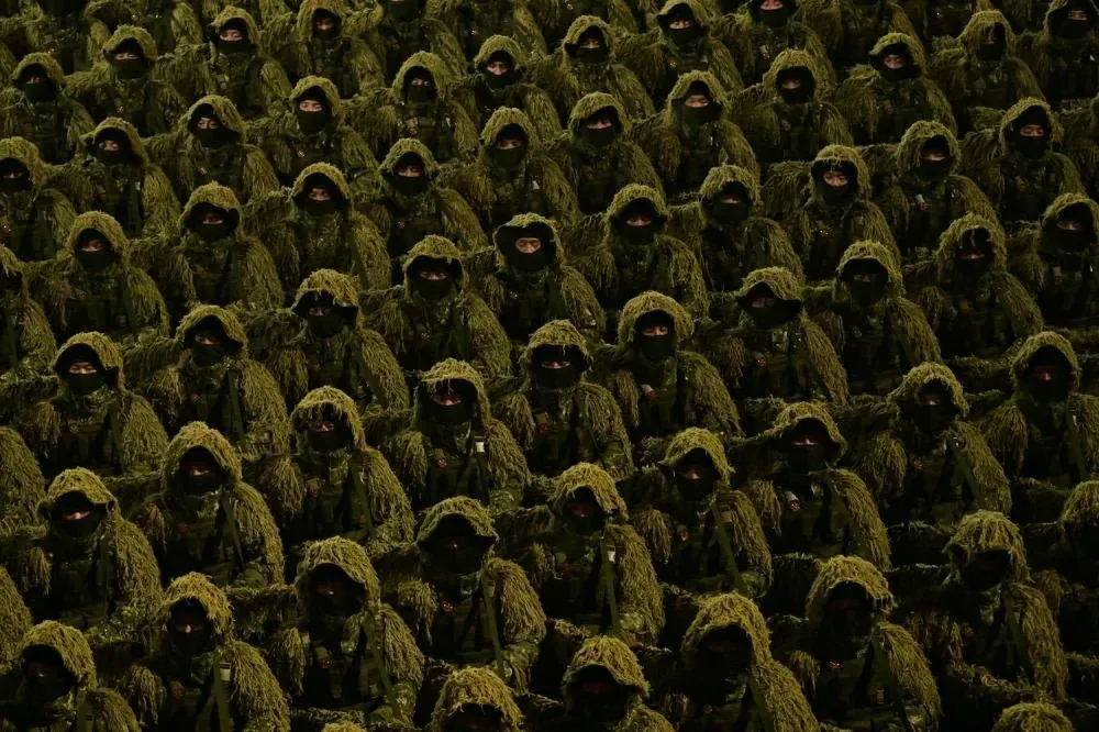 جنود كوريون شماليون يرتدون زي تمويه كثيف خلال عرض عسكري في بيونغ يانغ، مع التركيز على الانضباط العسكري والقدرات الاستراتيجية.
