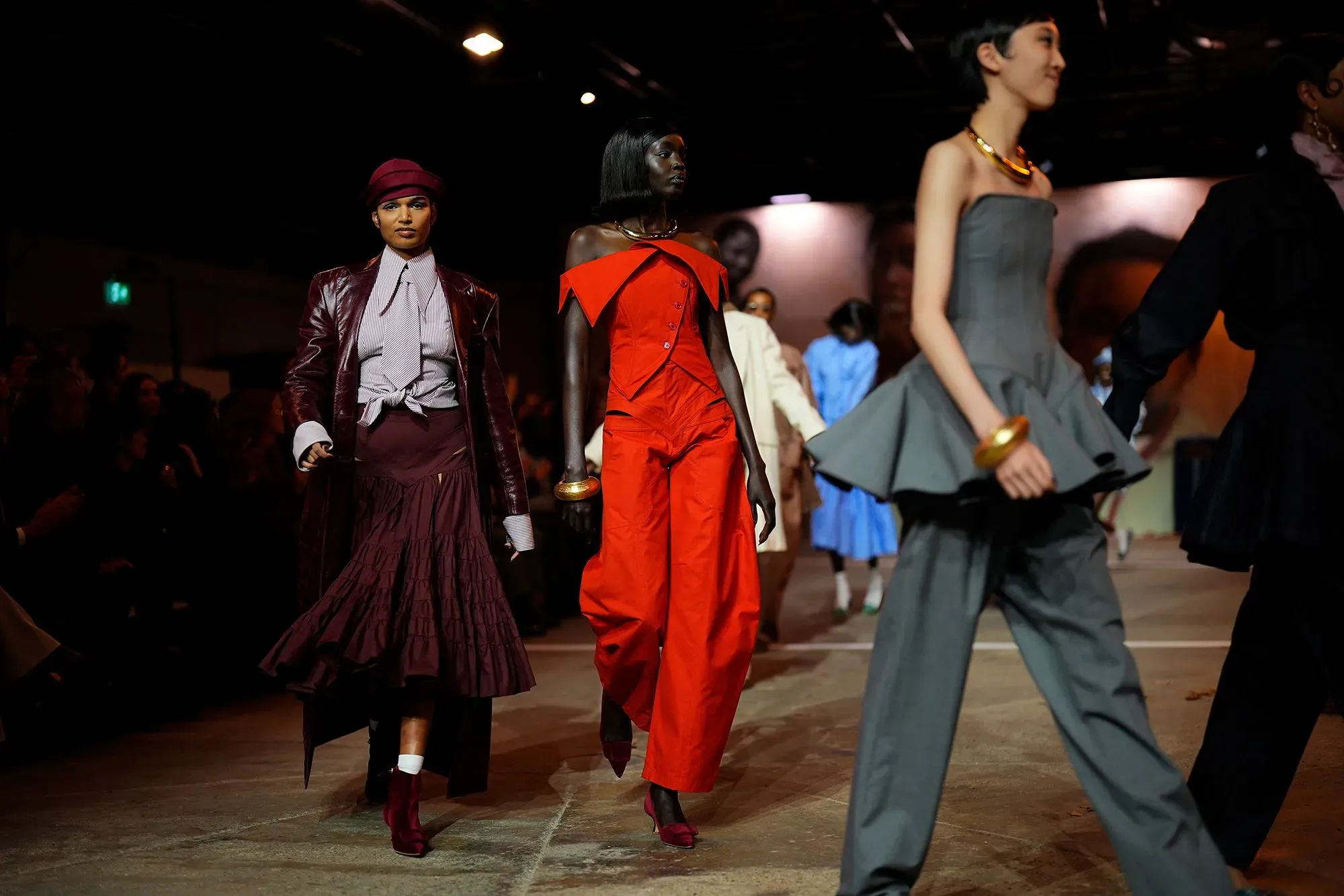 عرض أزياء يضم عارضات يرتدين أزياء متنوعة بألوان جريئة، مع التركيز على تصاميم تولو كوكر لخريف وشتاء 2026.