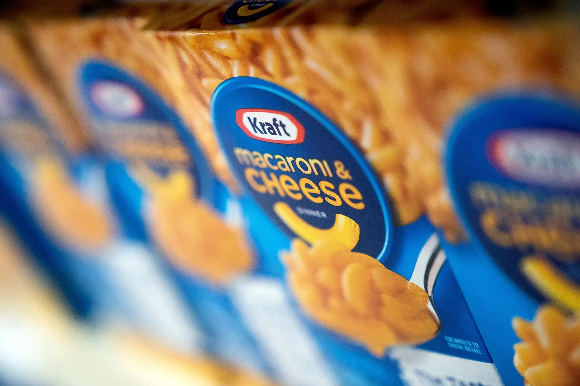 علب كرافت ماك آند تشيز تظهر في صورة قريبة، مع التركيز على العلامة التجارية، في سياق إعادة ابتكار المنتجات الغذائية الأساسية.