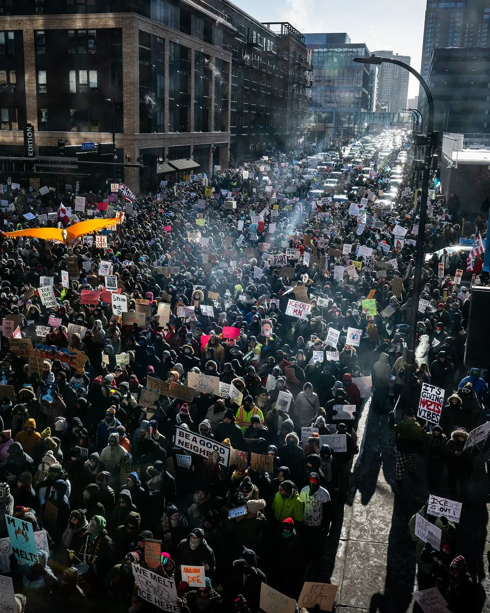 تجمع حشود كبيرة في شوارع مدينة مينيسوتا، حاملة لافتات تدعو إلى إنهاء عمليات الهجرة، وسط أجواء شتوية باردة.