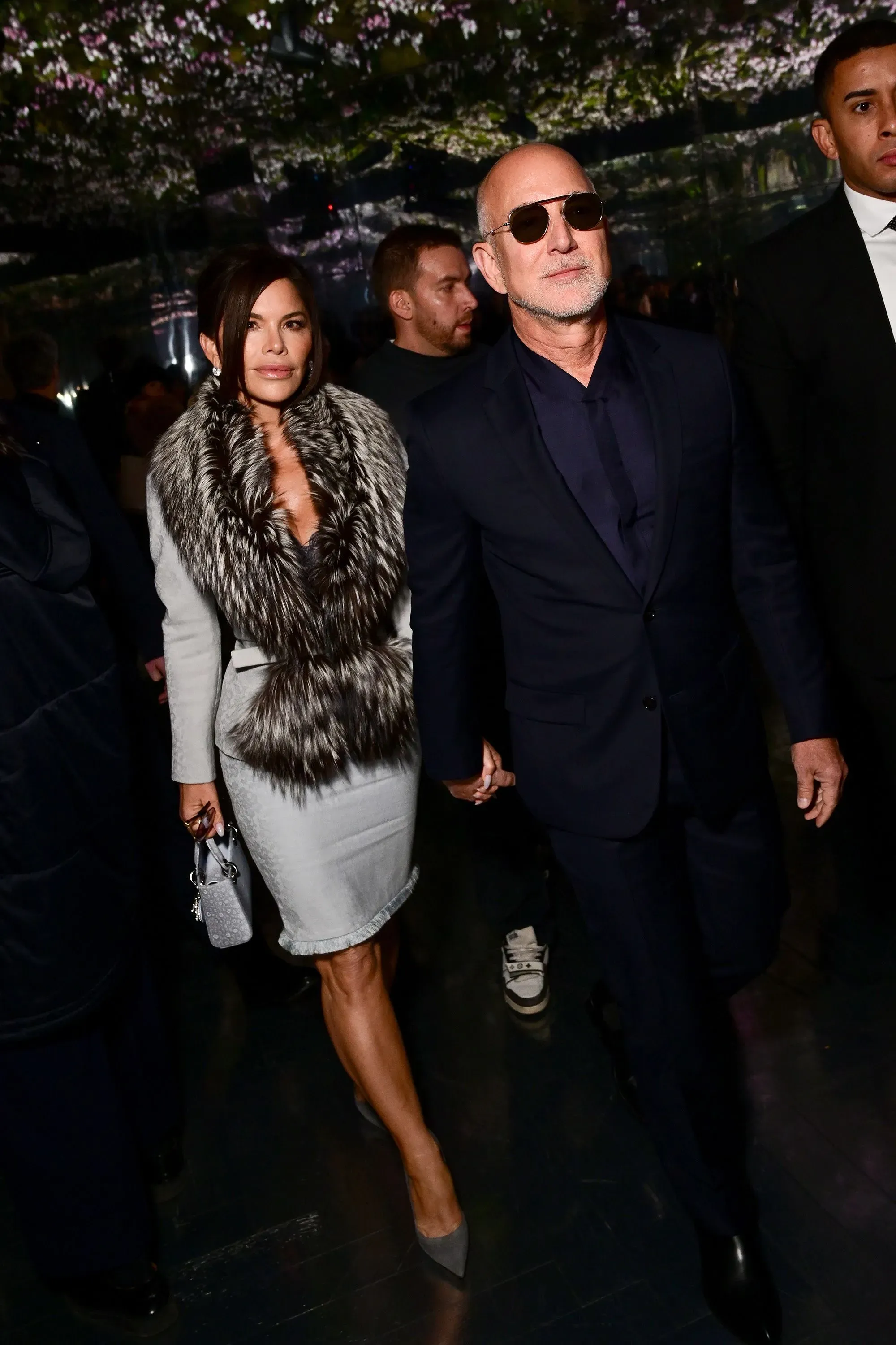 جيف بيزوس ولورين سانشيز بيزوس يتجولان معاً في أسبوع باريس للأزياء، حيث ترتدي سانشيز بدلة تنورة أنيقة مع حقيبة كلاتش.