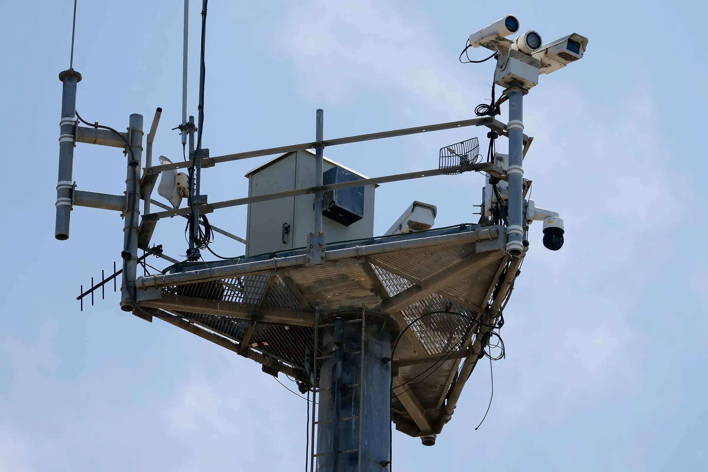 برج مراقبة مزود بكاميرات وأجهزة استشعار، يعكس استخدام الذكاء الاصطناعي في إنفاذ قوانين الهجرة وتعزيز الأمن.