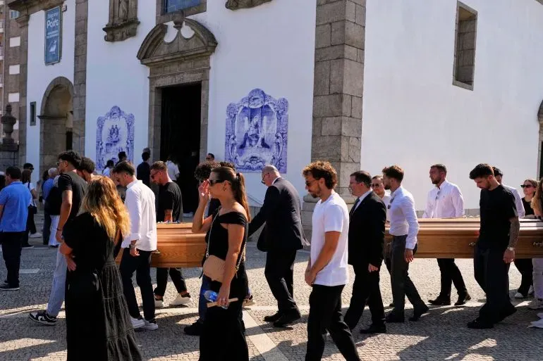 حضور المعزين في جنازة لاعبي كرة القدم ديوجو جوتا وشقيقه، حيث يحملون النعش أمام كنيسة في جوندومار، البرتغال.