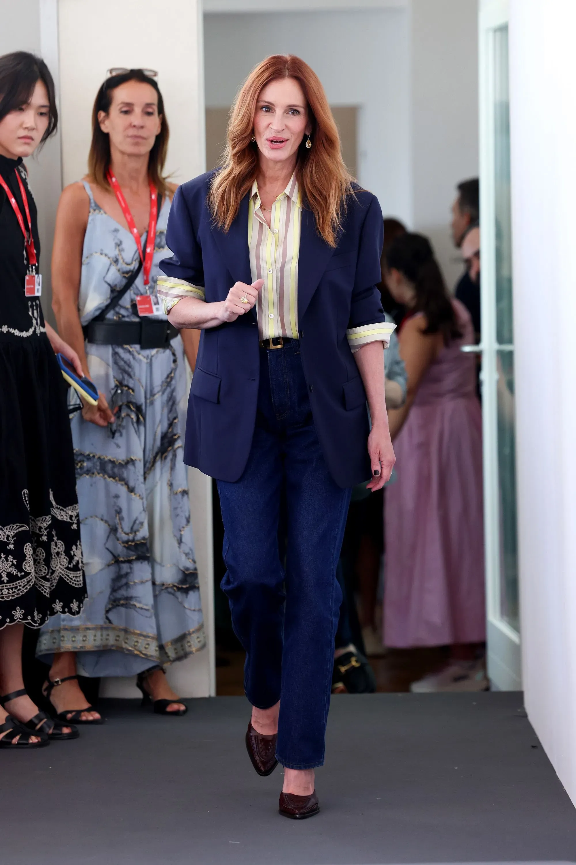 جوليا روبرتس ترتدي بنطلون جينز عالي الخصر وسترة كحلية وقميص مخطط، أثناء حضورها مهرجان البندقية السينمائي.