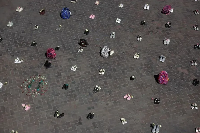 أحذية وحقائب مدرسية متفرقة على الأرض، تمثل ذكرى الأطفال الضحايا في الهجوم على مدرسة «شجرة طيّبة» الابتدائية في إيران.