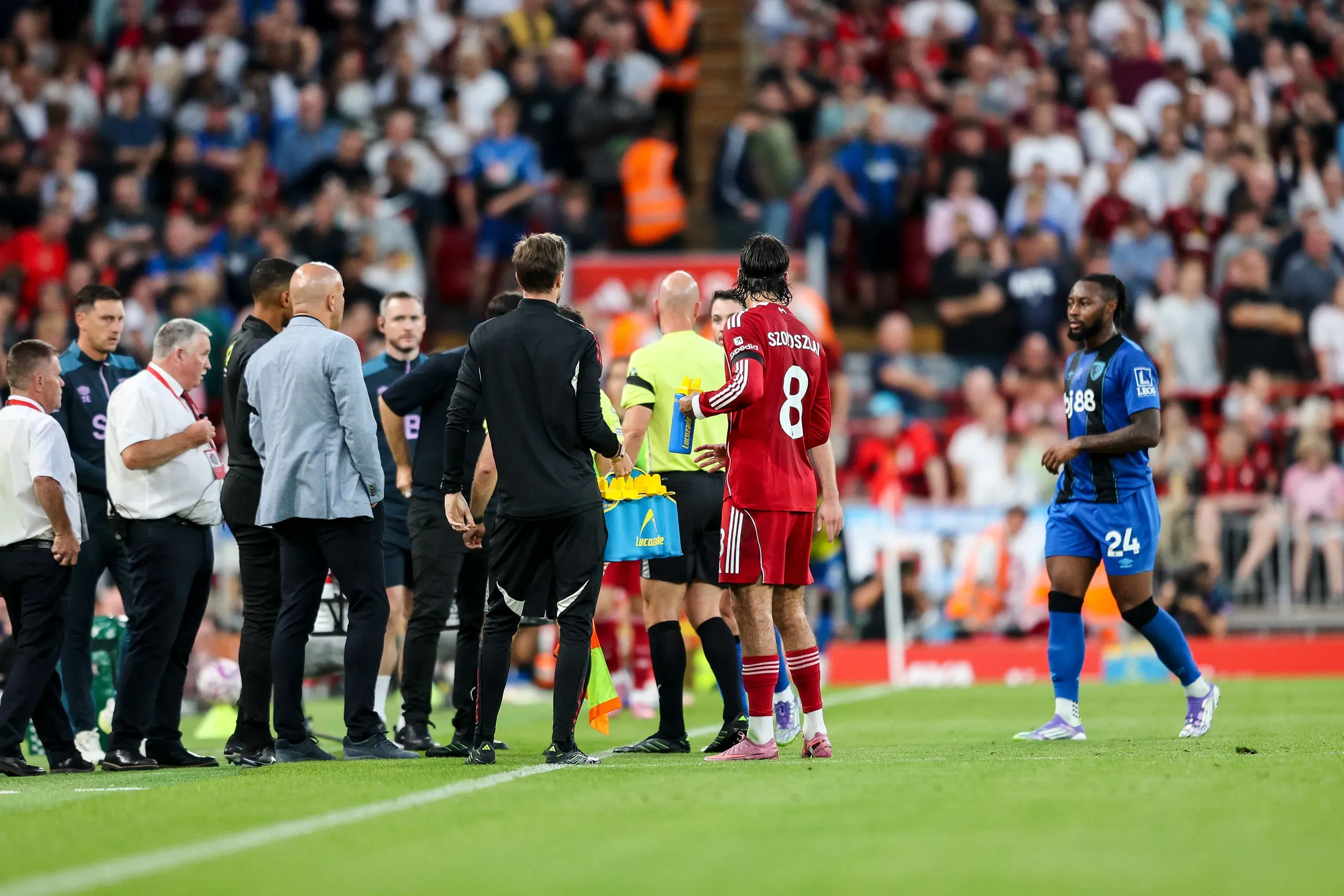 مشهد من مباراة الدوري الإنجليزي الممتاز بين ليفربول وبورنموث، حيث يتجمع المدربون واللاعبون لمناقشة حادثة إساءة عنصرية.