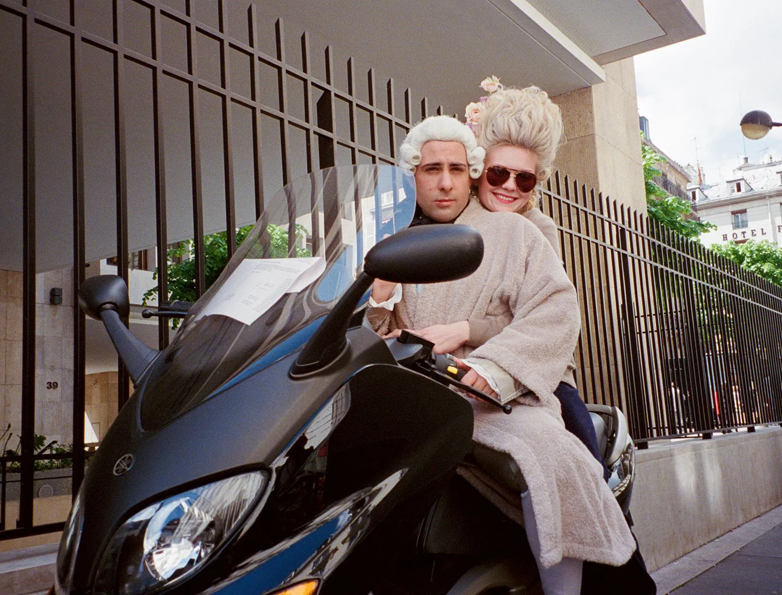 مراهقان يرتديان أزياء باروكية من فيلم «Marie Antoinette» لسوفيا كوبولا يجلسان على دراجة Vespa في باريس أثناء تصوير الفيلم عام 2006.