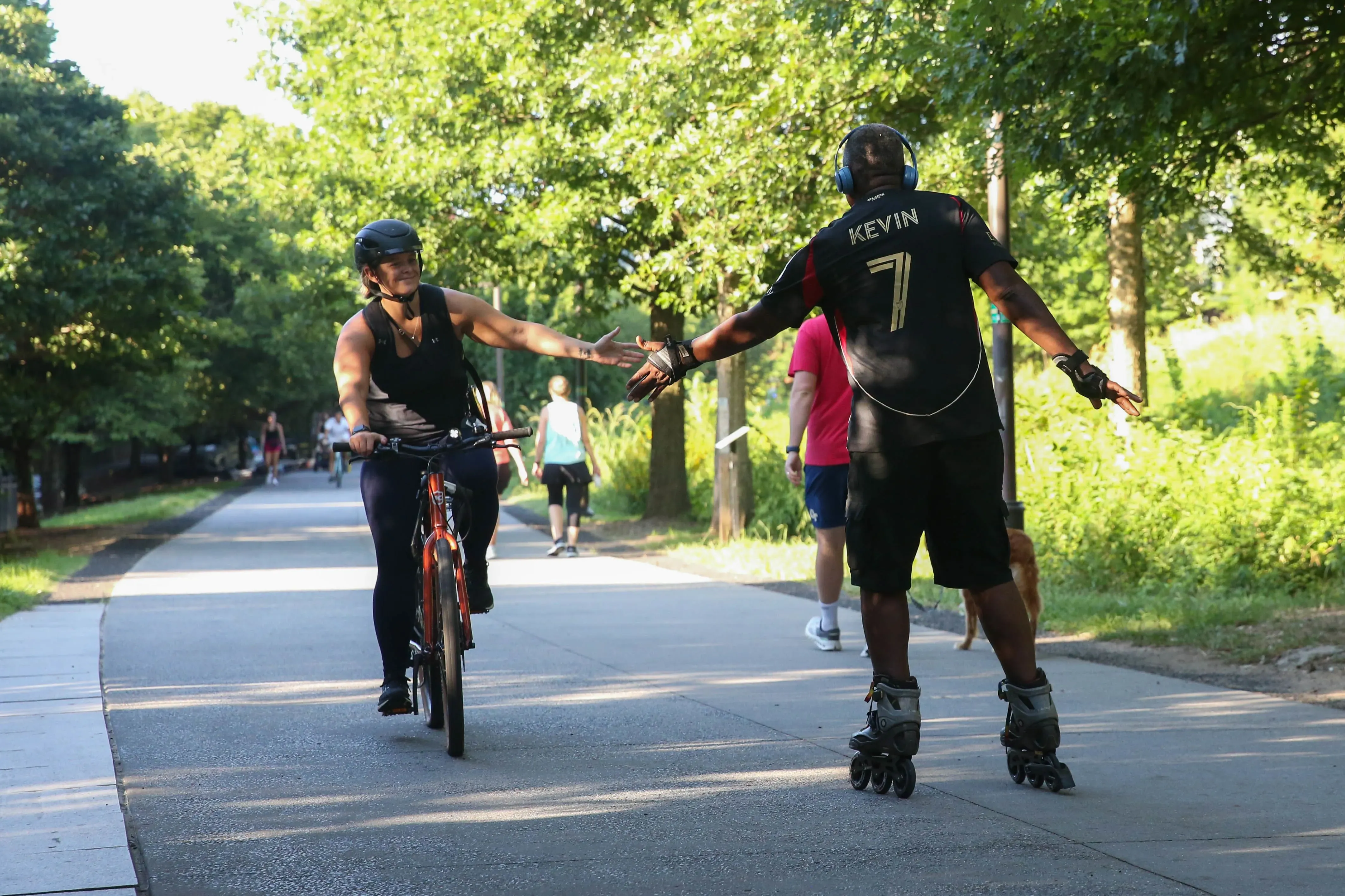 كيفن راندولف، رجل في الستينيات من عمره، يتزلج على العجلات في بيلت لاين بأتلانتا، يتفاعل مع راكب دراجة، مع وجود أشخاص آخرين في الخلفية.