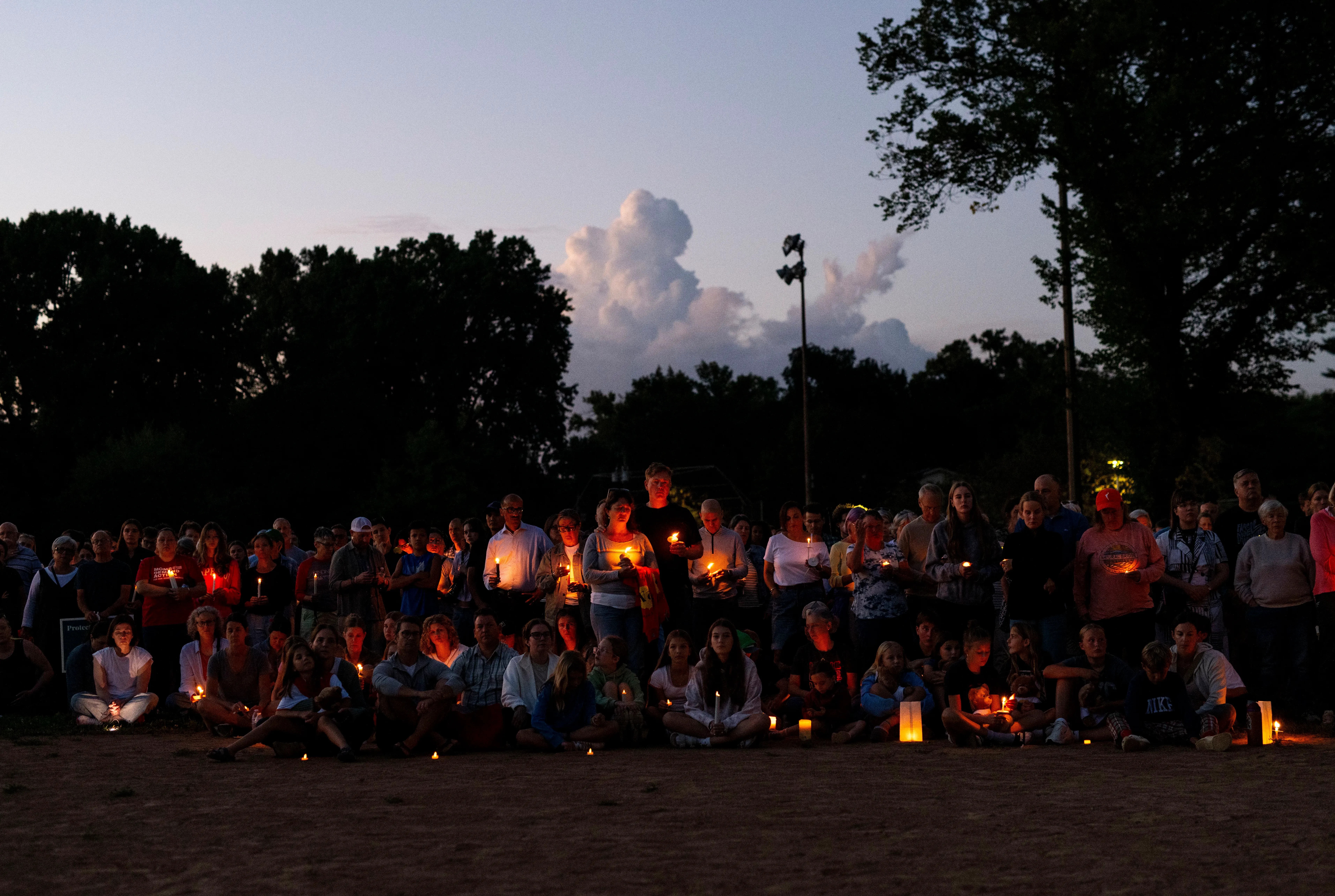 تجمع حشد من الآباء والأطفال في حديقة لينهارت بارك، حاملين الشموع في وقفة احتجاجية حدادًا على ضحايا العنف المسلح في مينيابوليس.
