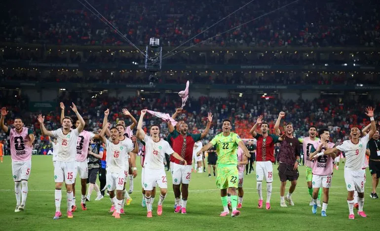 لاعبو منتخب المغرب لكرة القدم يحتفلون بفوزهم وتأهلهم إلى دور الستة عشر في كأس العالم وسط حماس الجماهير في ملعب Monterrey.