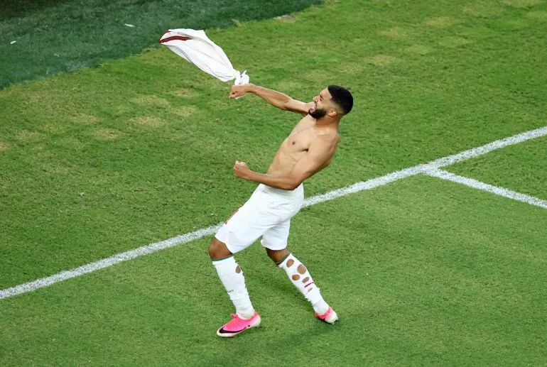 لاعب منتخب المغرب يحتفل بحماس بعد تأهل فريقه إلى دور الستة عشر في كأس العالم 2022.