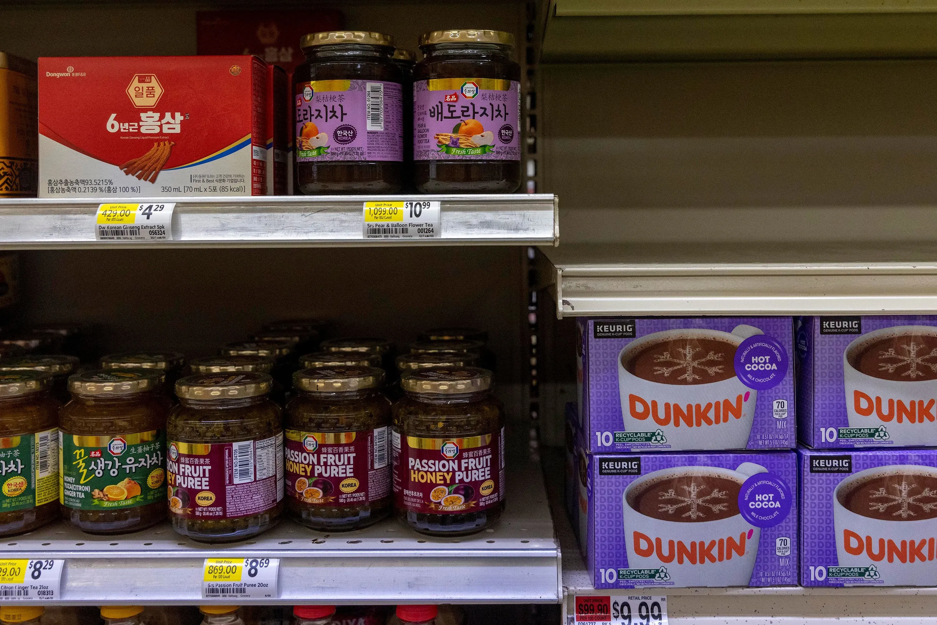 رفوف متجر بقالة تعرض مجموعة متنوعة من المنتجات الآسيوية، بما في ذلك صلصات ومشروبات كورية، تعكس تأثير الجالية الكورية في إيلابيل، جورجيا.