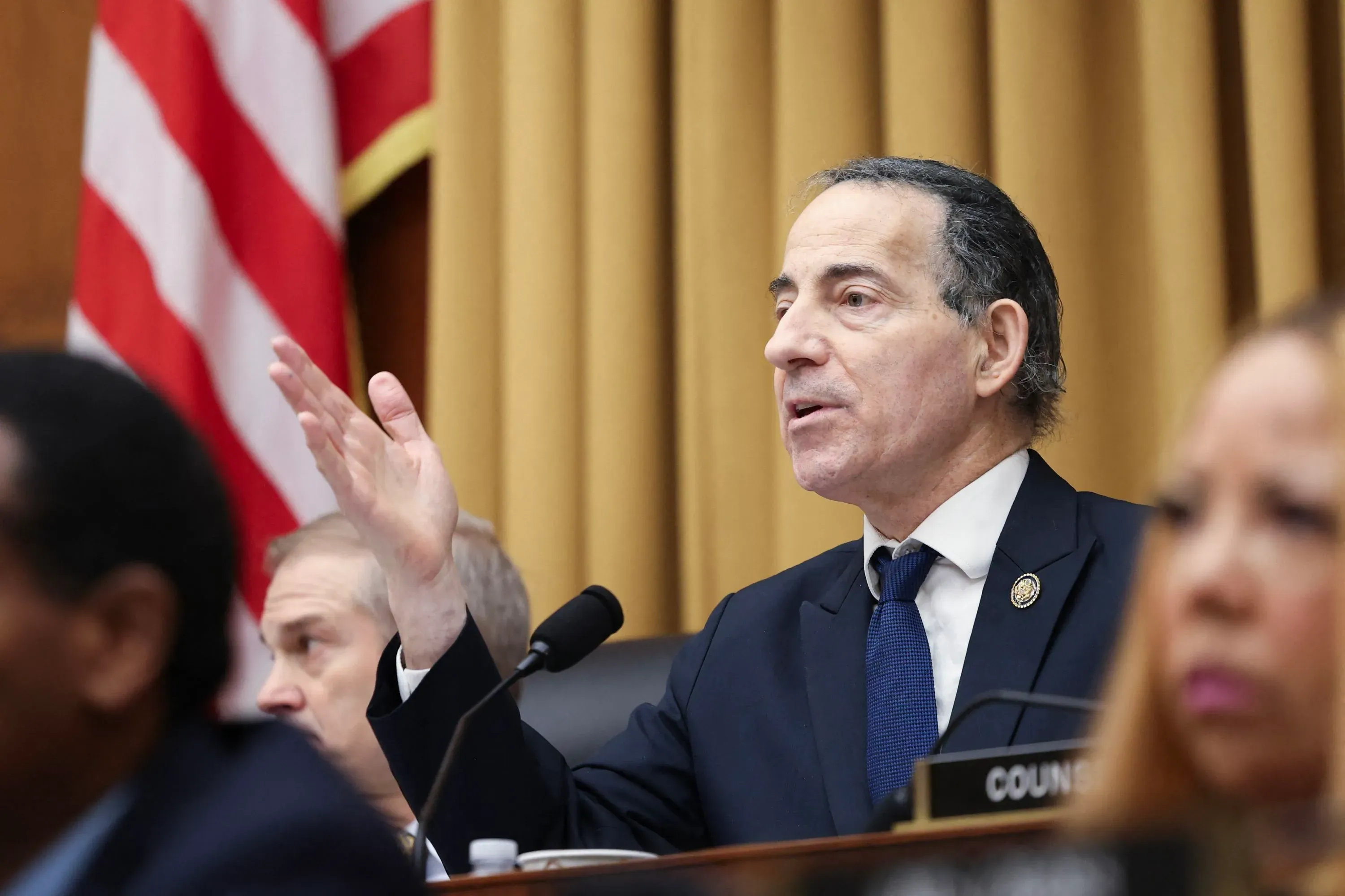 نائب في الكونغرس يتحدث خلال جلسة، مع وجود علم أمريكي خلفه، معبرًا عن قلقه بشأن تحقيقات وزارة العدل في قضية إبشتاين.