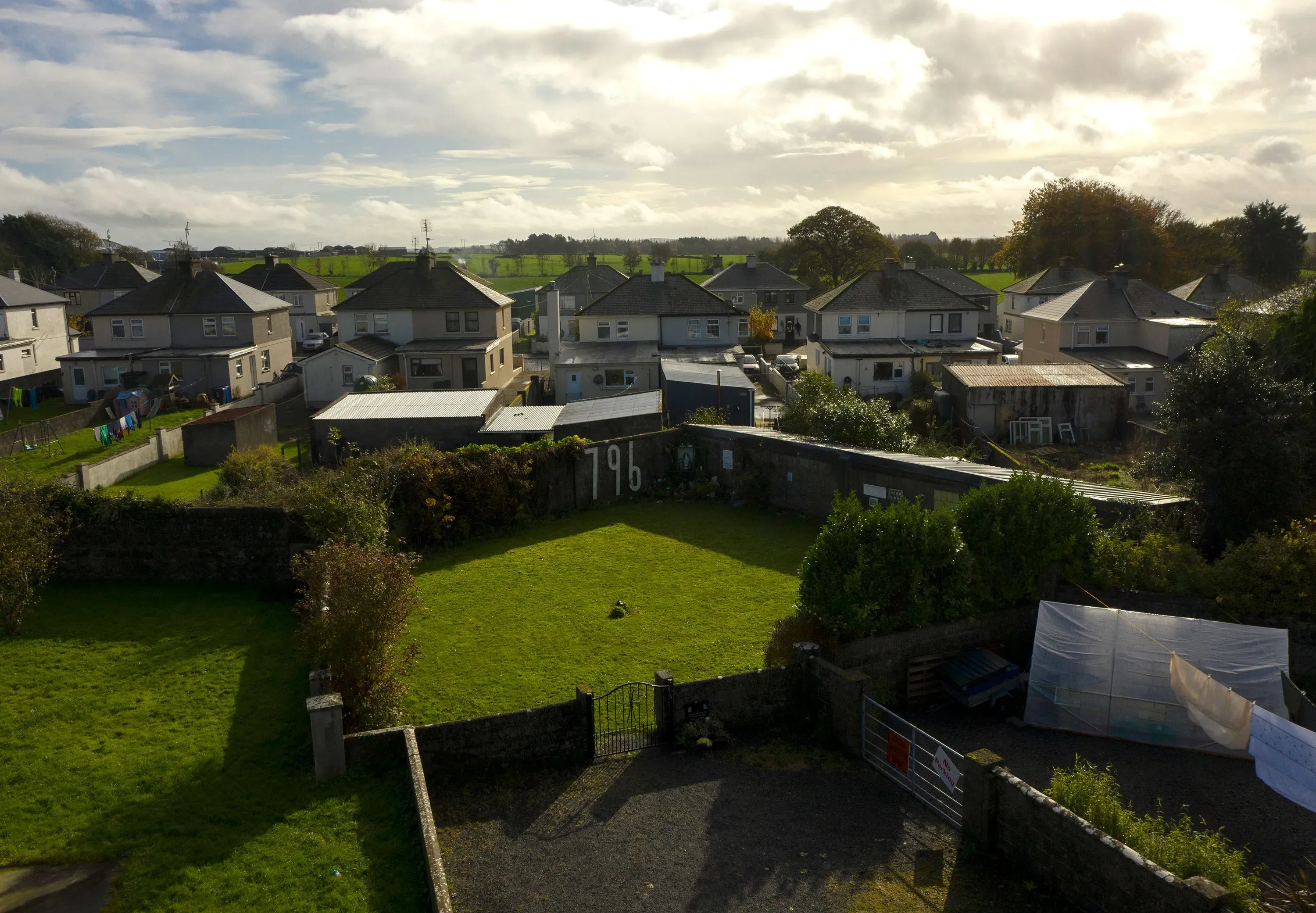 منظر جوي لمنطقة دفن ثانية للرضع في توام، أيرلندا، مع وجود منازل محيطة، حيث تم العثور على رفات 796 رضيعًا.