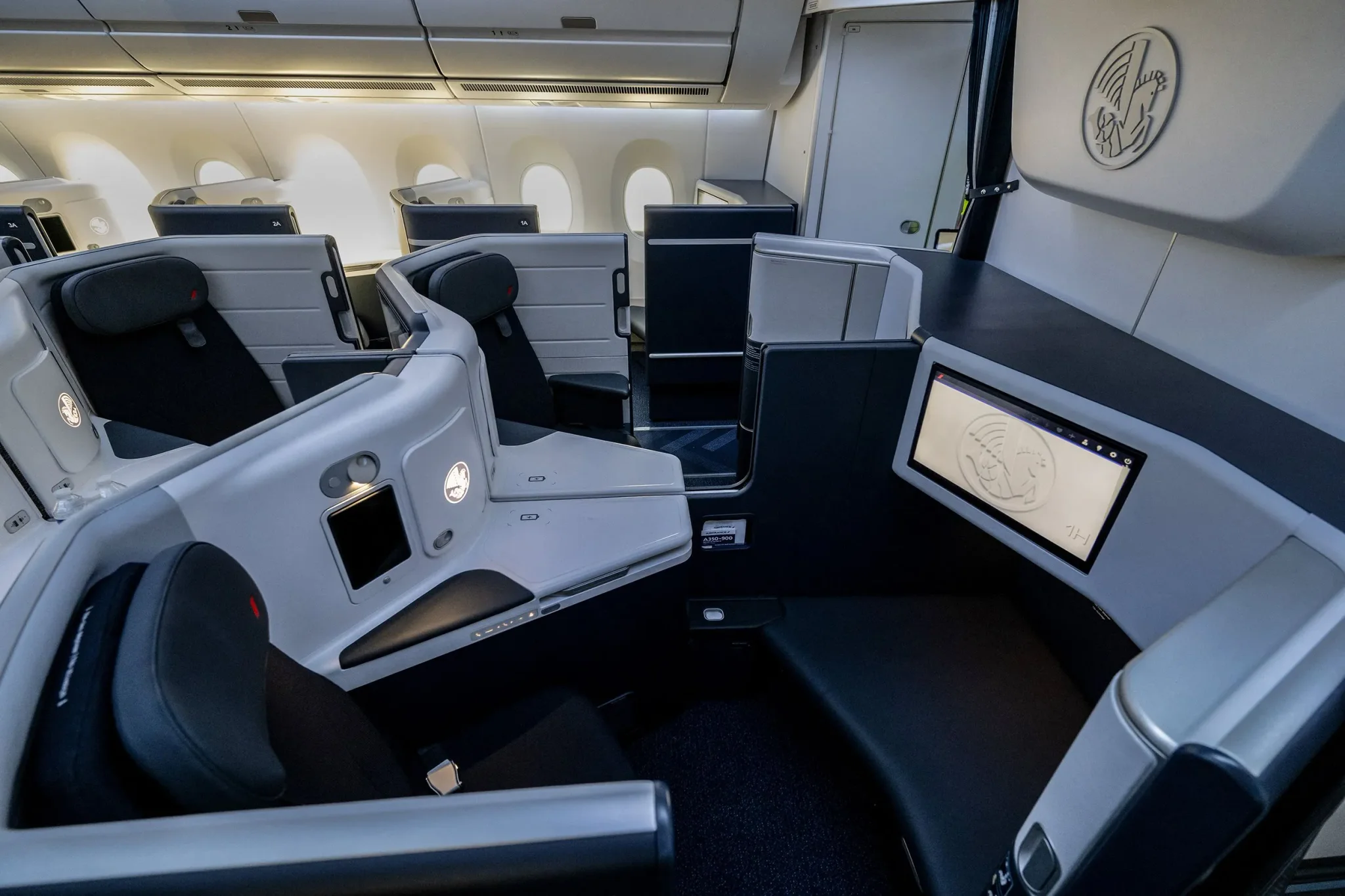 مقصورة درجة رجال الأعمال الفاخرة لطائرة Airbus A350 مع مقاعد أفقية وأبواب انزلاقية تعكس تحديات اعتماد تصميمات المقاعد الحديثة في الطيران.