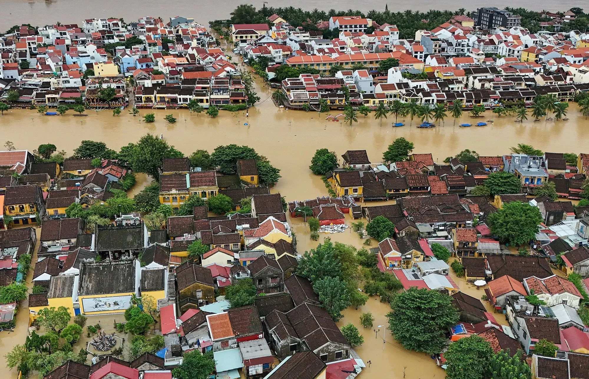 منظر جوي لمدينة غارقة بالمياه بسبب الفيضانات، يظهر المنازل والمباني المحاطة بالمياه، مما يعكس تأثيرات تغير المناخ.