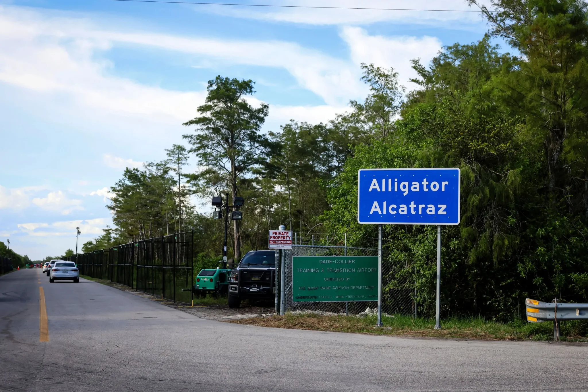 علامة "Alligator Alcatraz" على مدخل مركز الاحتجاز في مستنقعات فلوريدا، محاطة بالأشجار، تعكس الجدل حول أوضاع المحتجزين.