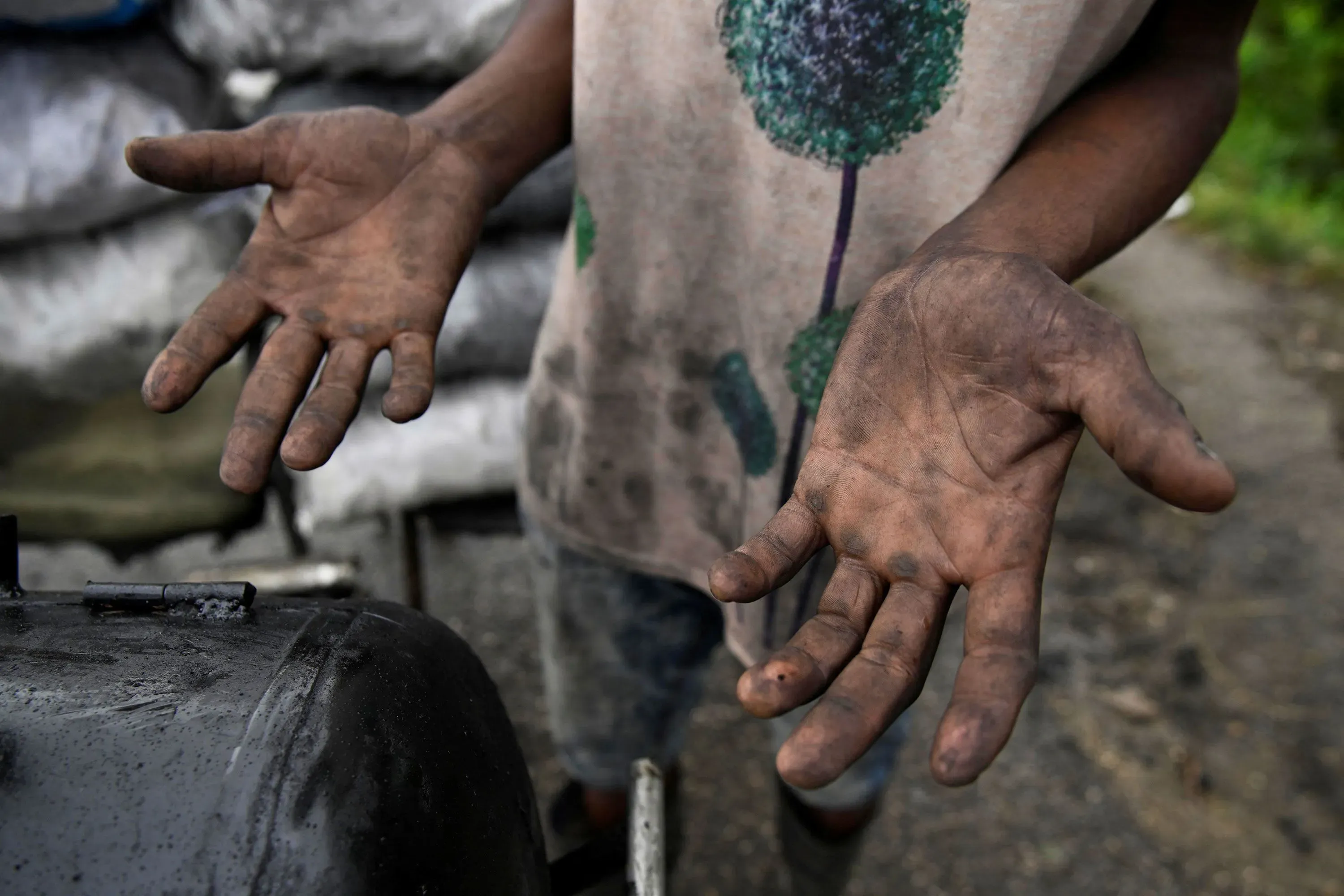 أيدي شخص متسخة بالزيت، تشير إلى الصعوبات الاقتصادية في كوبا، حيث يعاني السكان من نقص الوقود والموارد الأساسية.