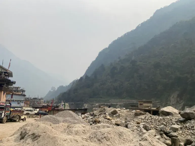 منظر للقرية المهجورة ناغا في سيكيم، مع منازل متصدعة وأرض مغطاة بالأنقاض، تعكس آثار الفيضان المدمر في 2023.