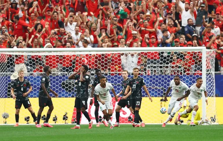 لاعبو منتخب المغرب يحتفلون بهدف في مرمى كندا خلال مباراة دور الـ16 في كأس العالم، وسط حماس الجماهير المغربية.