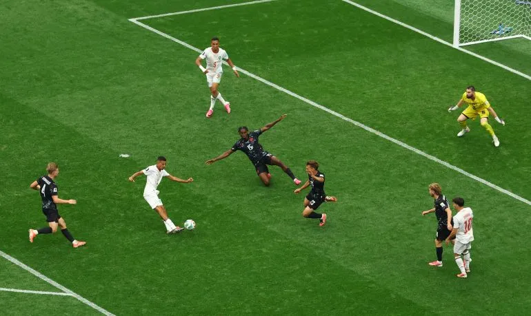 لاعب كندا يطلق تسديدة نحو مرمى المغرب وسط تكتل دفاعي من أسود الأطلس في مباراة دور الـ16 من كأس العالم 2022.