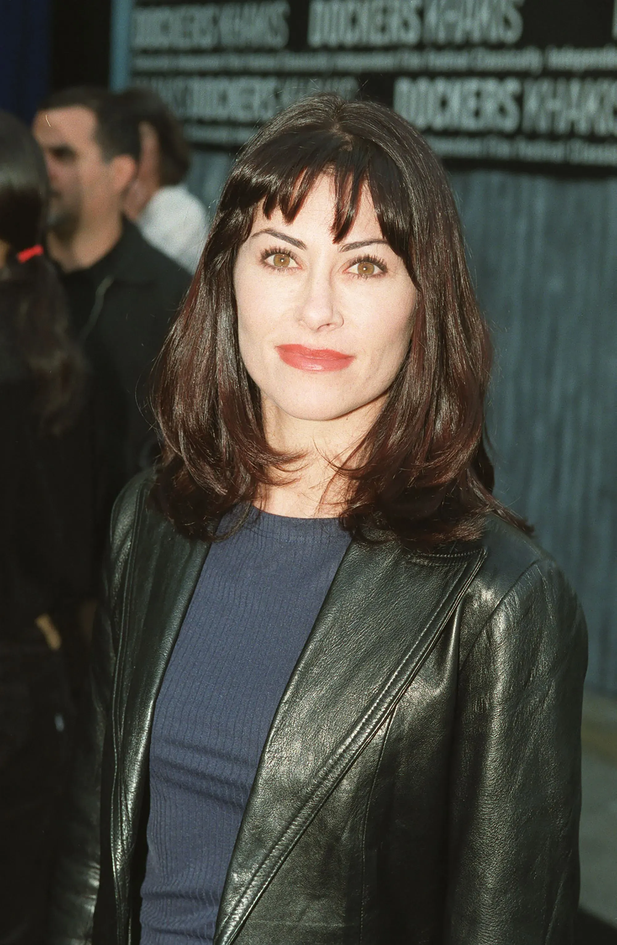 امرأة ترتدي سترة جلدية سوداء، ذات شعر بني داكن، وتبتسم في حدث عام، تعكس نجاحات الفنانين الشباب في جوائز إيمي.