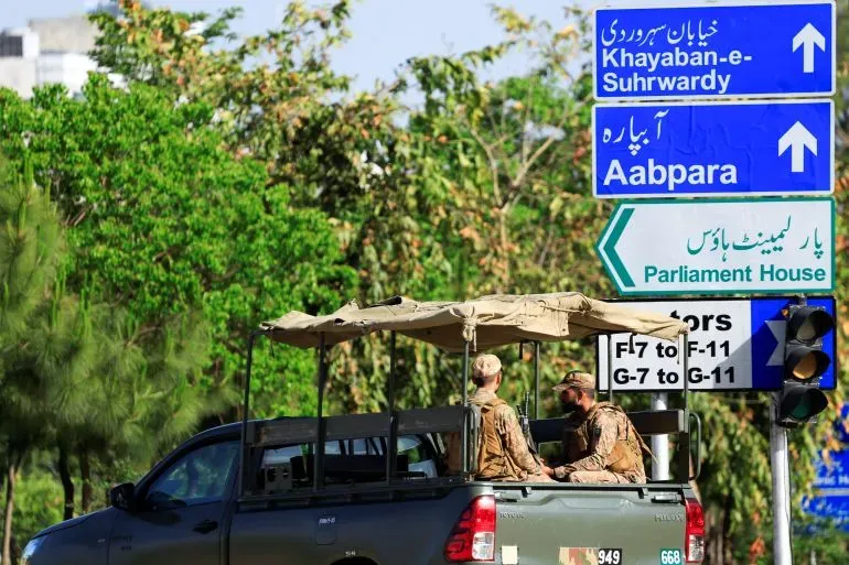 جنود يجلسون في مركبة عسكرية في إسلام آباد، مع لافتات تشير إلى الاتجاهات، في ظل استعدادات لمفاوضات بين الولايات المتحدة وإيران.