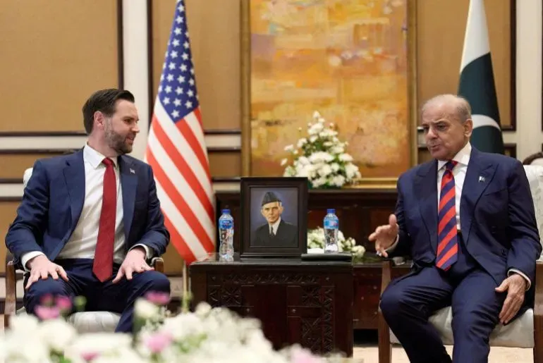 اجتماع بين ممثلين أمريكيين وباكستانيين في إسلام آباد، مع العلم الأمريكي وصورة مؤسس باكستان في الخلفية، استعدادًا لمفاوضات مع إيران.