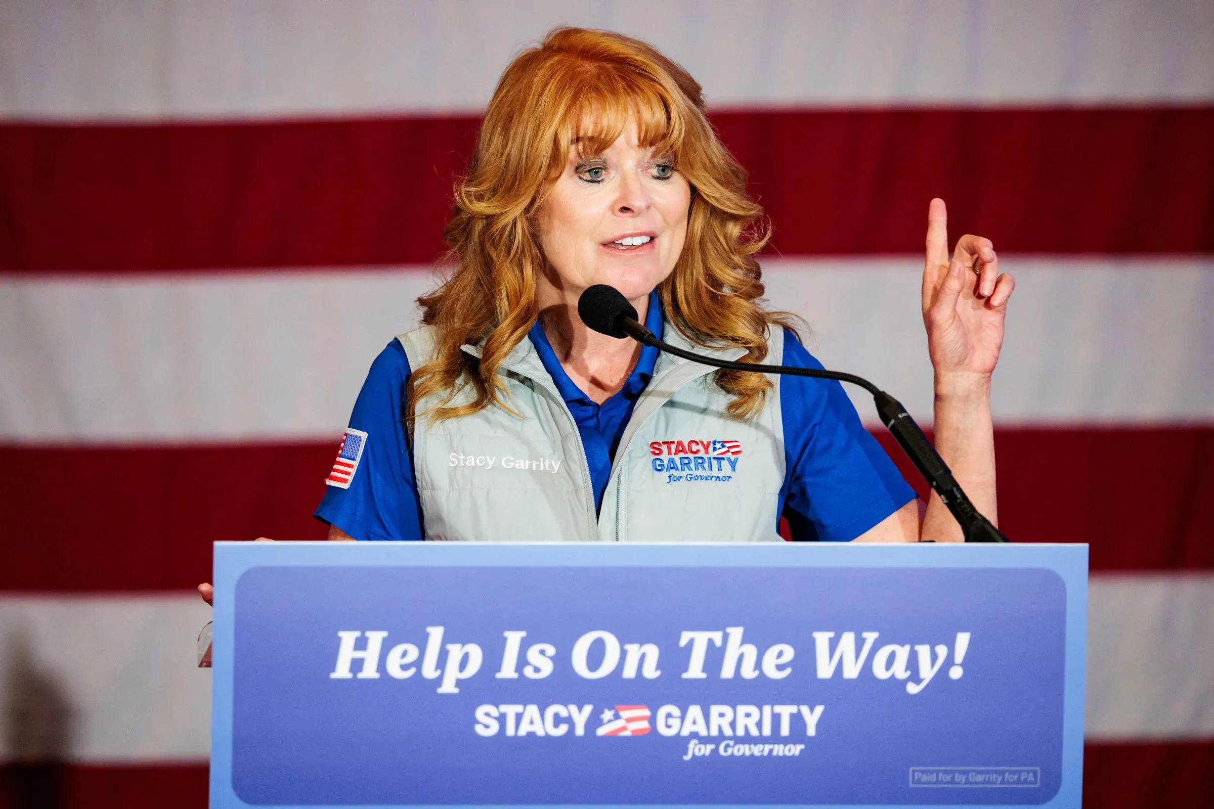 ستاسي غاريتي، مرشحة حاكم ولاية بنسلفانيا، تتحدث في تجمع انتخابي، مع العلم الأمريكي خلفها، تعبر عن رؤيتها للولاية.