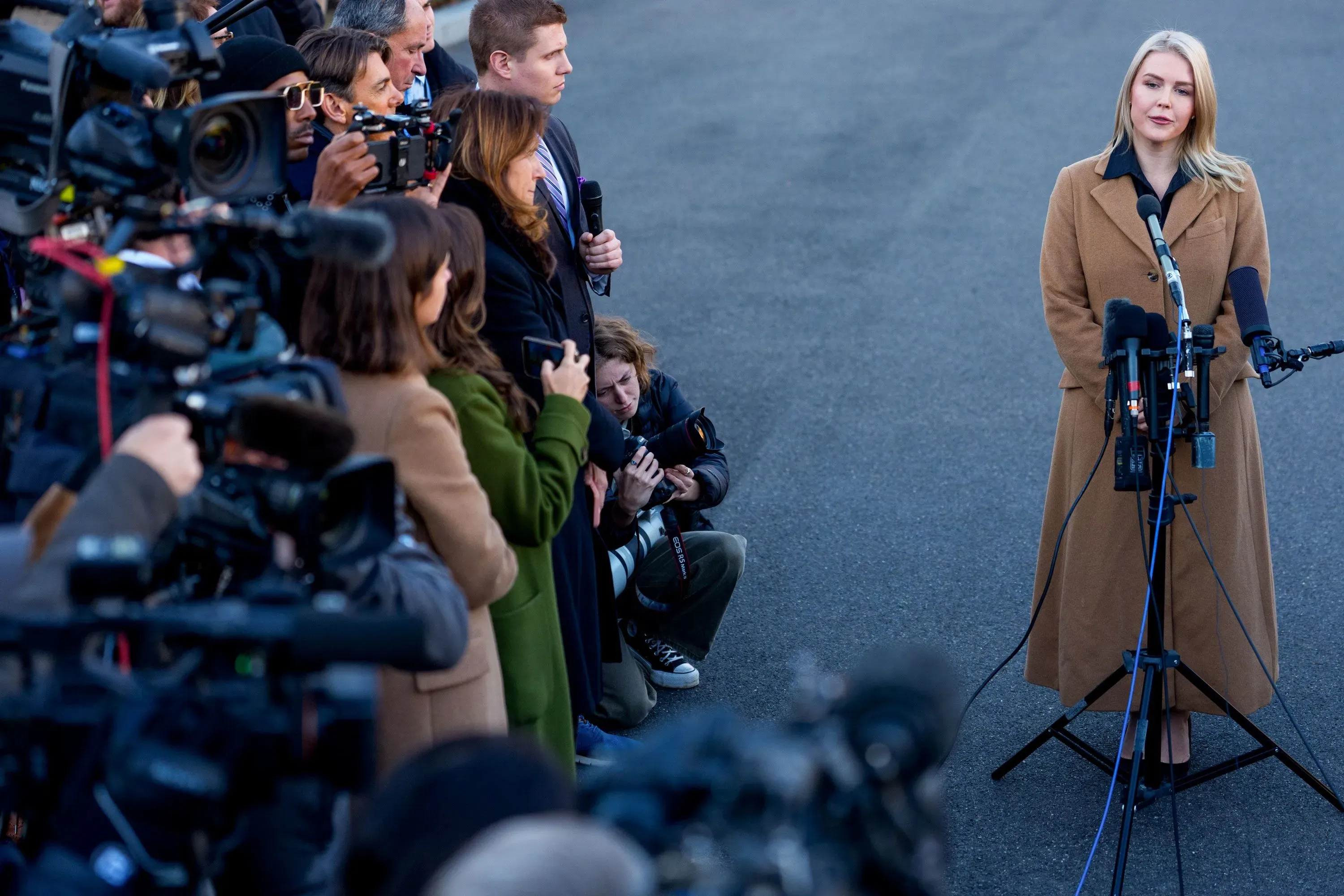 امرأة تتحدث إلى الصحفيين أثناء مؤتمر صحفي، محاطة بعدد كبير من الكاميرات والمراسلين، في مشهد يعكس التوتر السياسي الحالي.