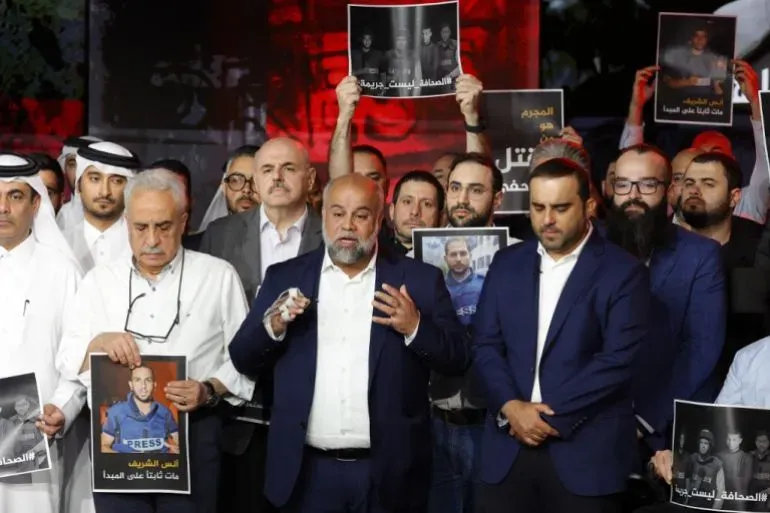 محتجون يحملون صور صحفيين قُتلوا في غارة إسرائيلية على غزة، يتجمعون في وقفة تأبينية لدعوة المجتمع الدولي للمساءلة.