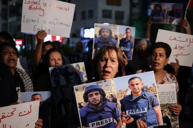 تجمع محتجون يحملون لافتات وصور صحفيين قُتلوا في غزة، معبرين عن مطالباتهم بمحاسبة المسؤولين عن الهجمات ضد الإعلاميين.