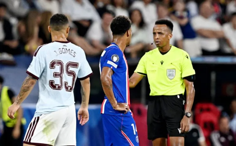 الحكم عمر أرتان يوجه إنذارًا للاعب من أستون فيلا خلال نهائي كأس السوبر الأوروبي بين باريس سان جيرمان وأستون فيلا.
