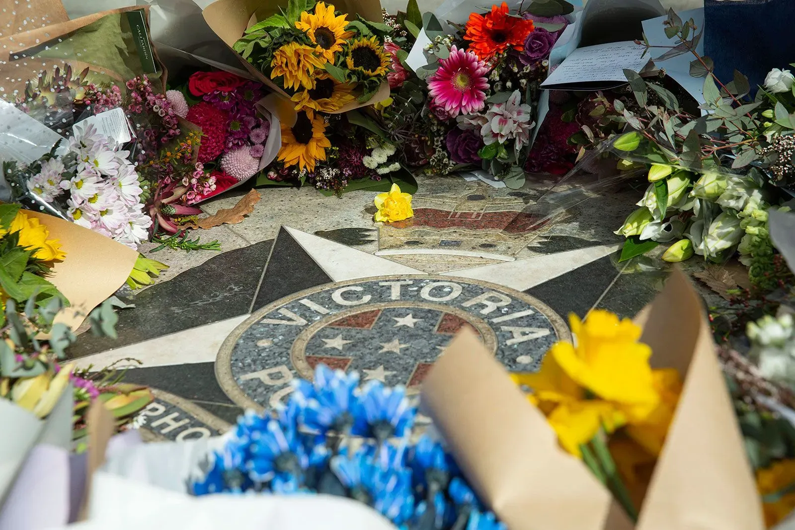 تجمع الزهور الملونة حول نجمة تحمل شعار شرطة فيكتوريا، في تكريم للضباط الذين فقدوا حياتهم أثناء أداء واجبهم.