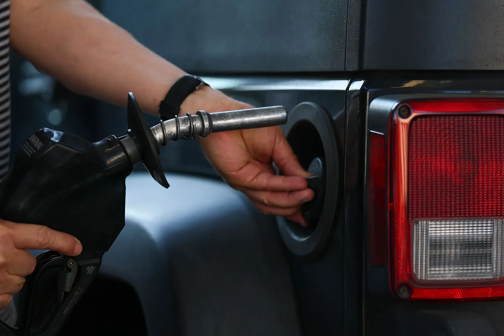 شخص يملأ خزان وقود سيارة باستخدام مضخة، في ظل ارتفاع أسعار الوقود بسبب نقص الإمدادات الناجم عن الحرب في الشرق الأوسط.